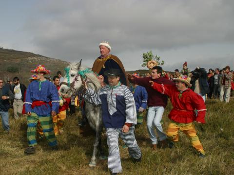 Carnaval de Covelo con la figura del Rei a la cabeza de la comitiva de los danzantes subiendo al Coto de la Reina.